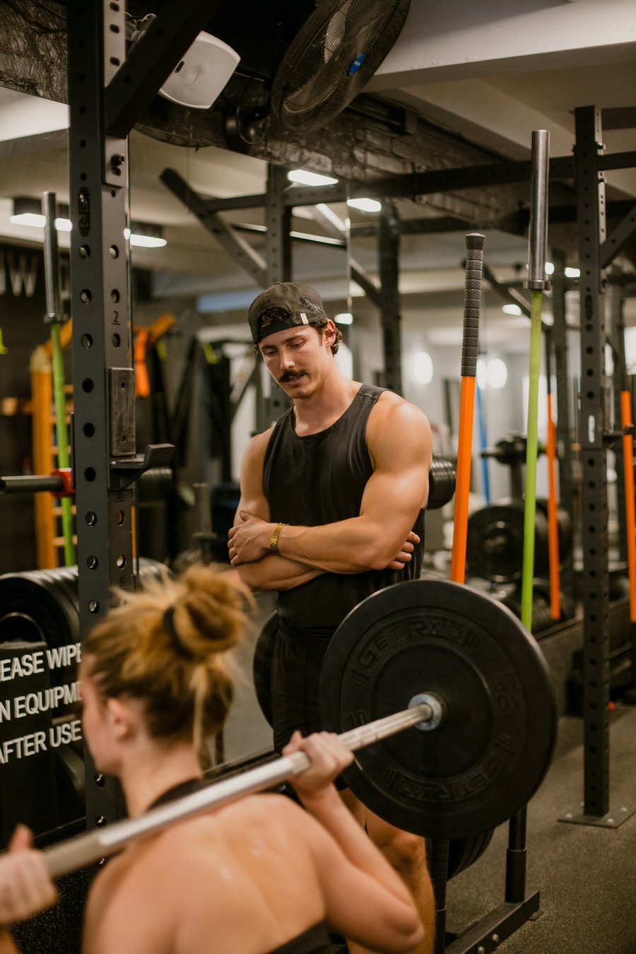 Coach observing client during back squat